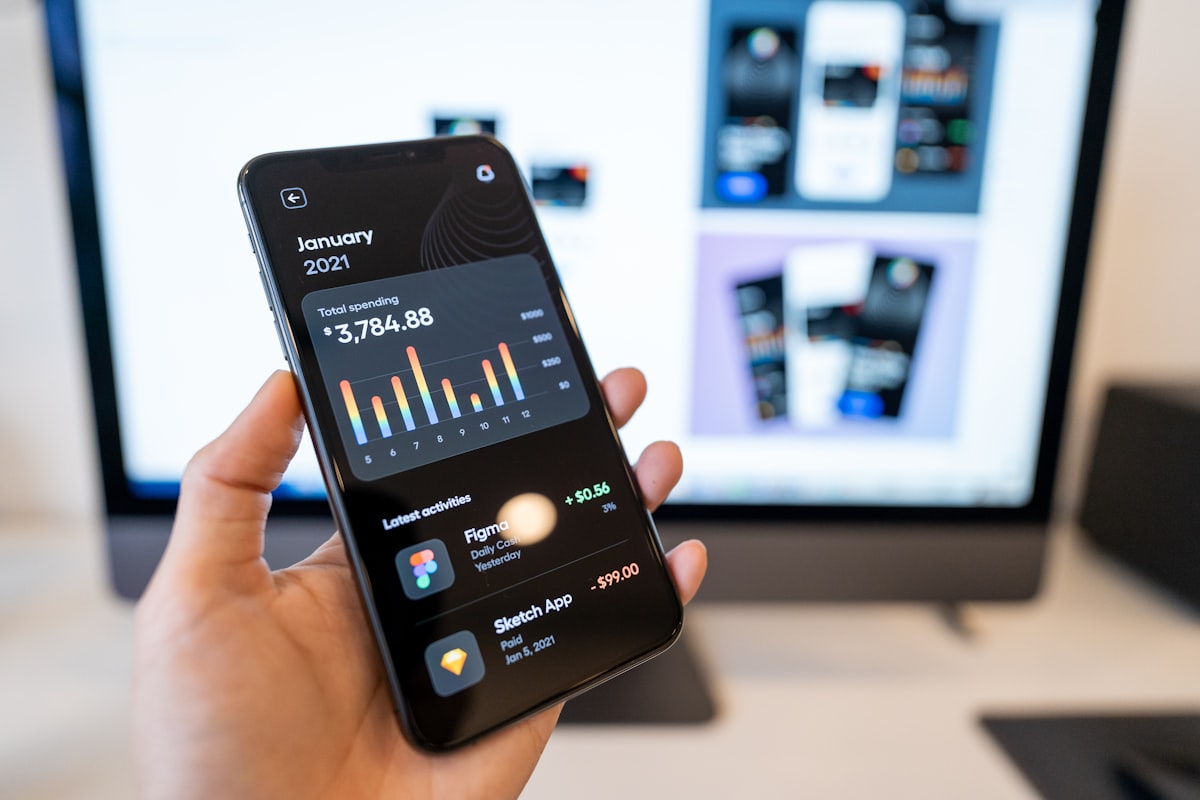 Person holding a smartphone with a mobile banking app open — representing digital financial security and cross-channel fraud detection