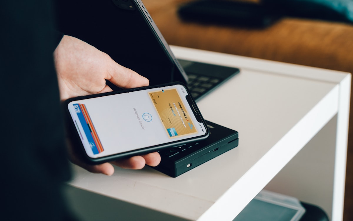 Pessoa realizando pagamento por aproximação com smartphone em uma maquininha