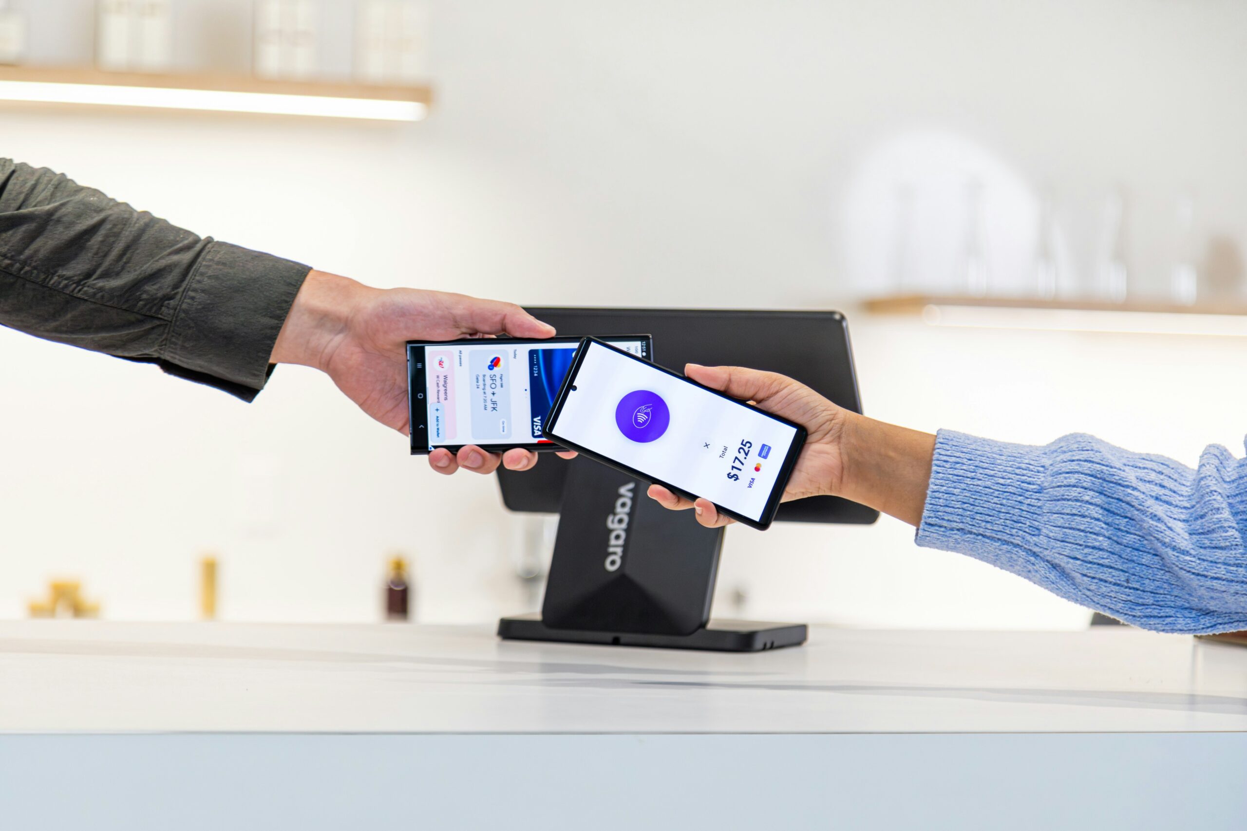 Cliente realizando pagamento por aproximação com o celular em terminal point-of-sale, ilustrando a infraestrutura de pagamentos digitais que o Banco Central planeja convergir com Drex, Open Finance e tokenização de ativos.